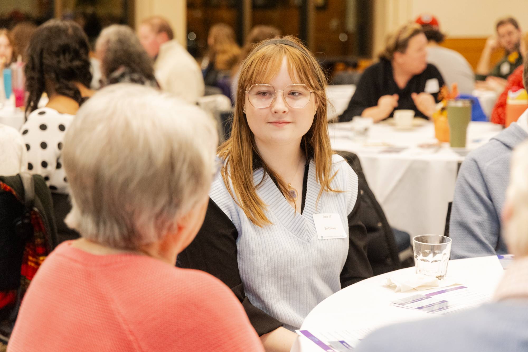 Gen Z attendee listens closely to an older attendee